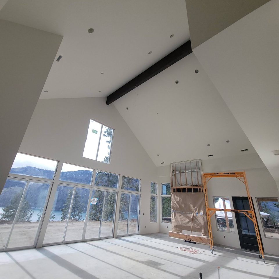 Interior room with high ceiling, windows, and scaffolding visible during work in progress.