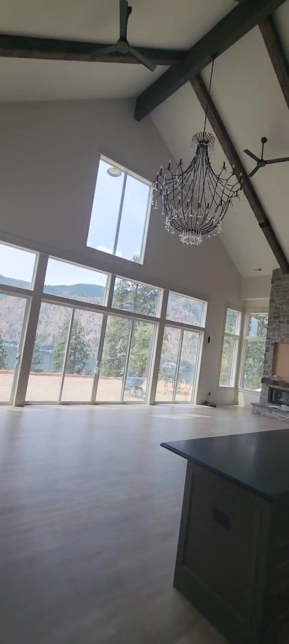 Interior video showing a bright living room with tall windows and a fireplace.