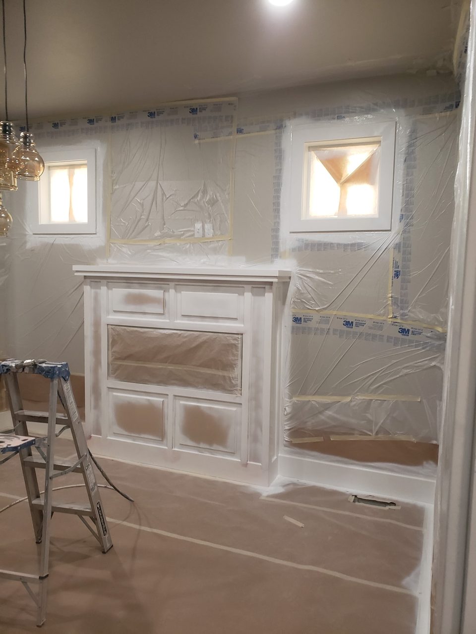 Interior fireplace area with protective coverings during work.