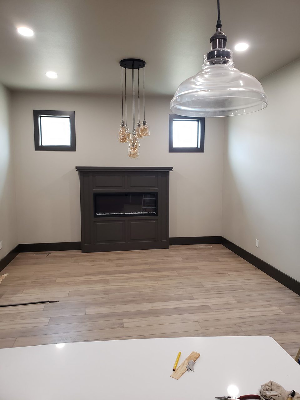 Interior view with pendant lights and a dark fireplace wall.
